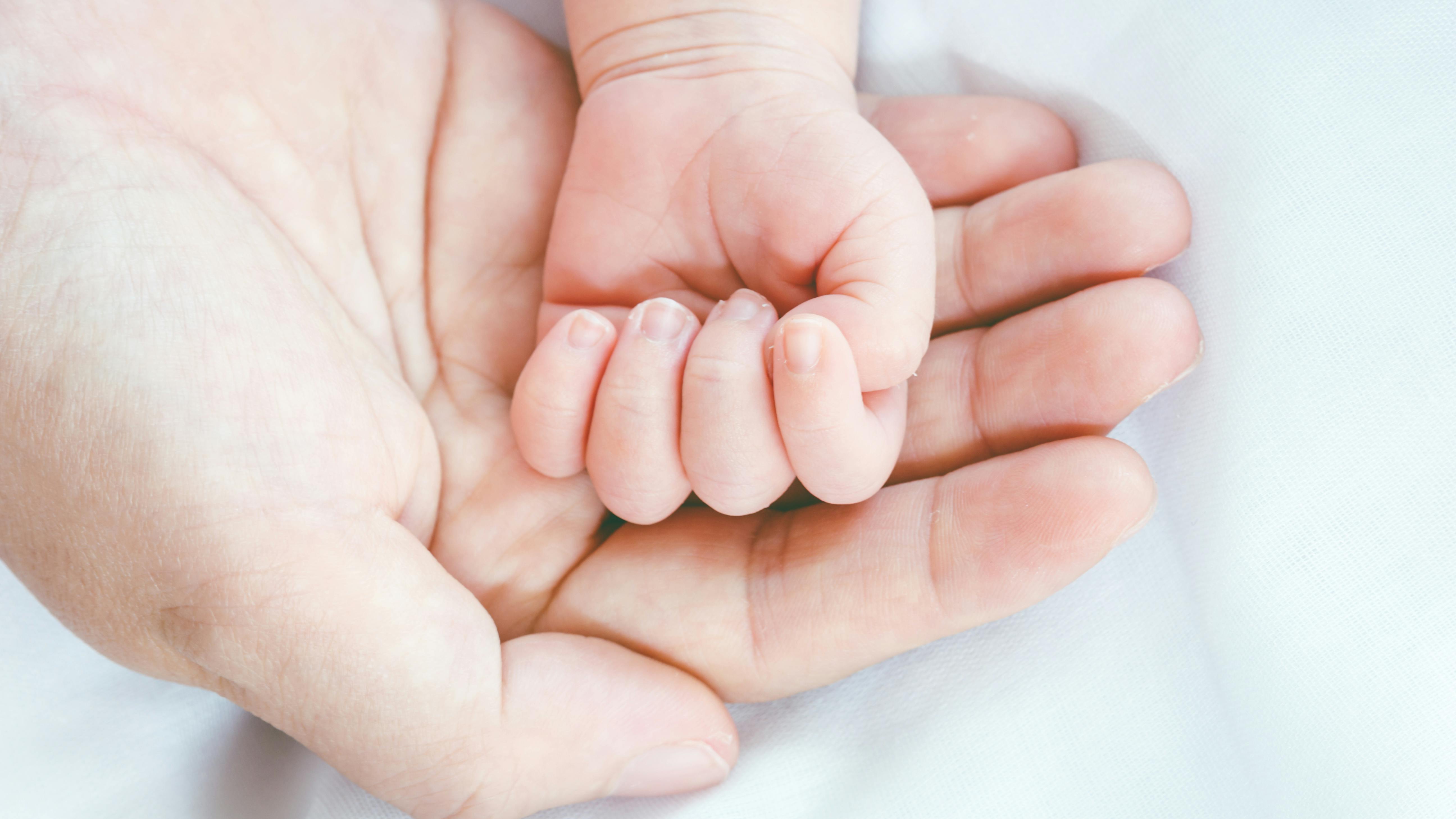 Nyfødts hånd i sin mors