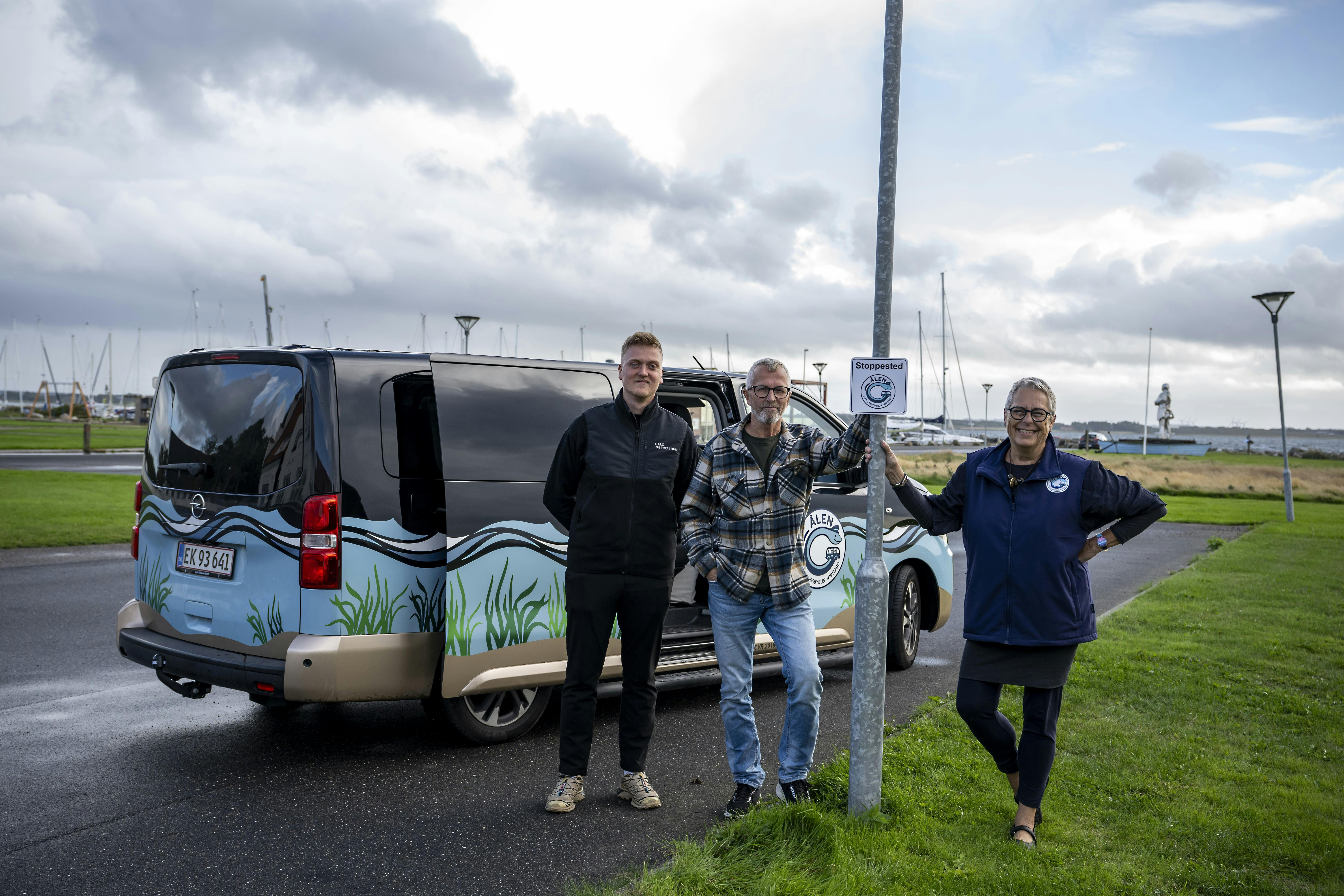 Lisbet Emmery ved ”Ålens” stoppested på havnen sammen med to andre frivillige chauffører Jacob Mikkelsen (t.v.) og Søren Petersen (t.h.).