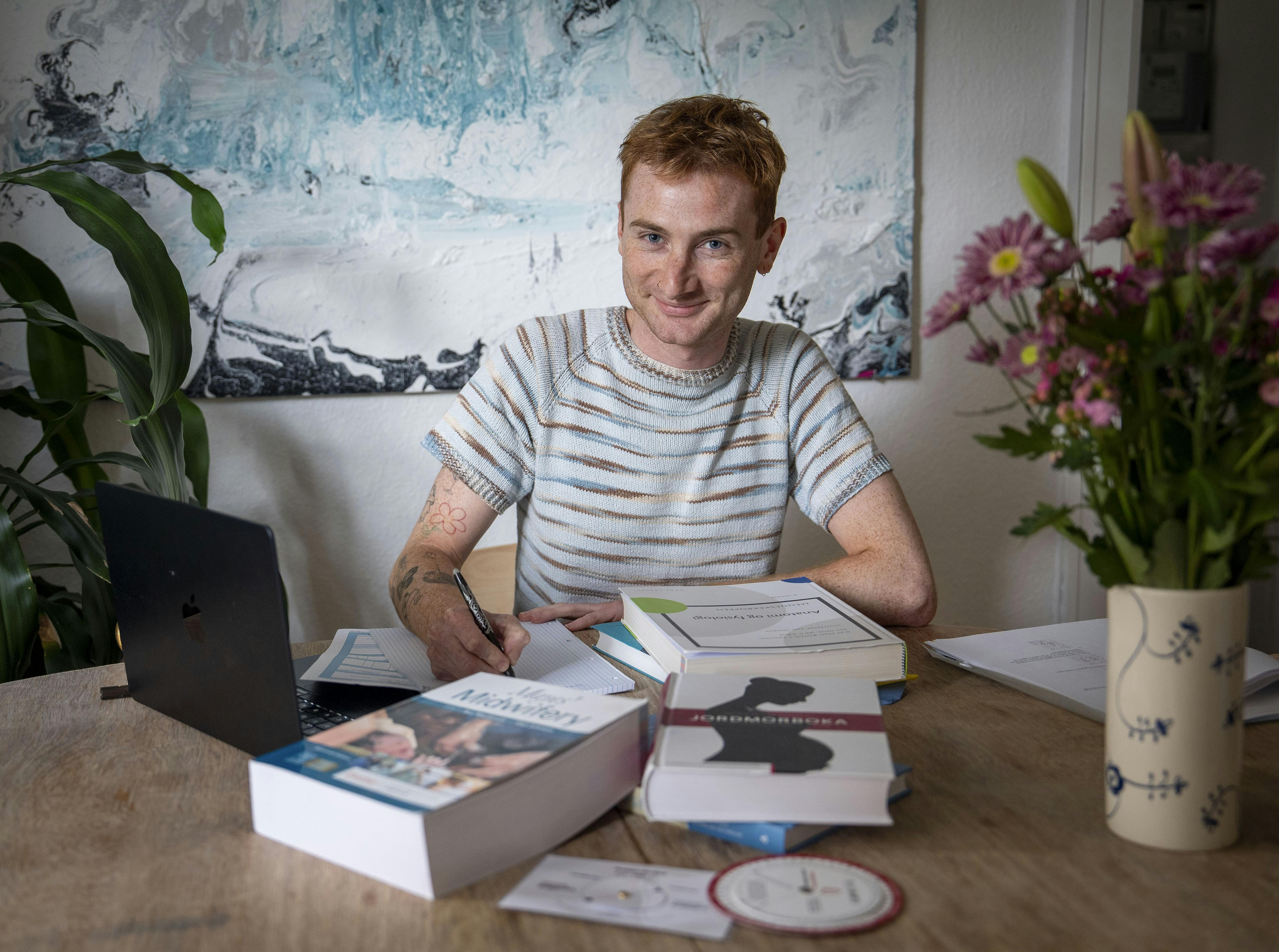 Osvald Kirkeby, en mandlig jordemoderstuderende, sidder med sine studiebøger