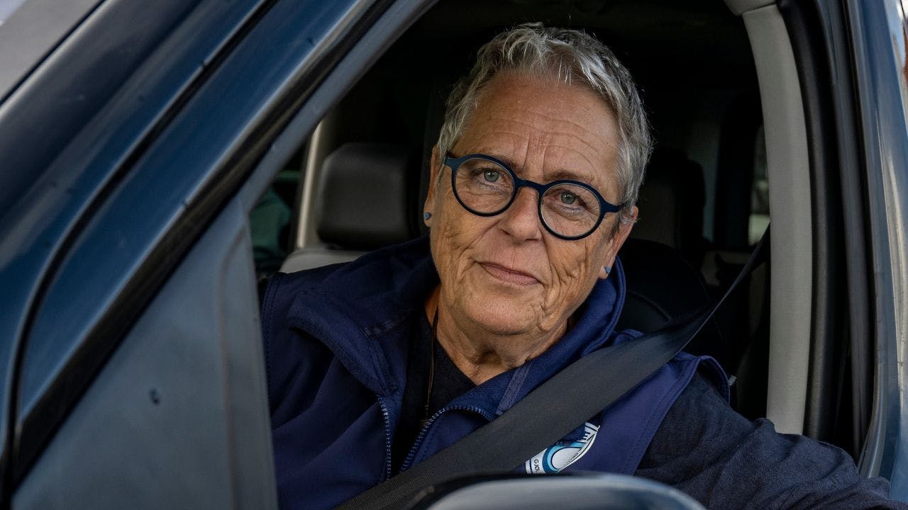 Lisbet Emmery ved ”Ålens” stoppested på havnen sammen med to andre frivillige chauffører Jacob Mikkelsen (t.v.) og Søren Petersen (t.h.).