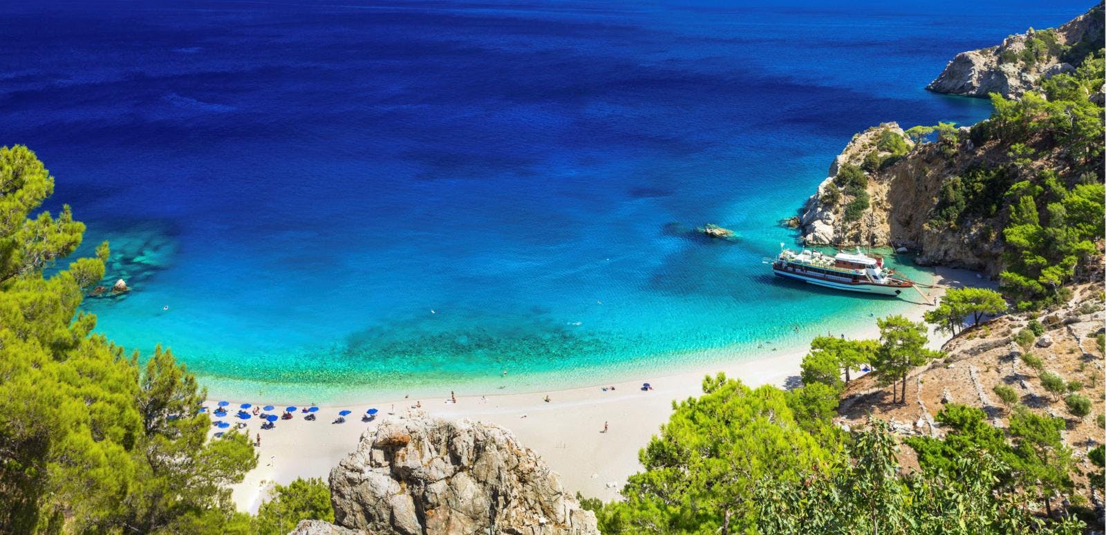 Azurblåt hav og en ren sandstrand.