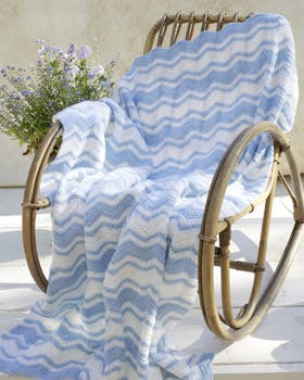 Stort hæklet tæppe på stol