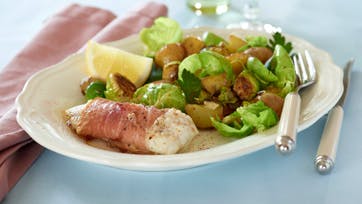 Ovnbagt fisk med parmaskinke, rosenkål og kartofler