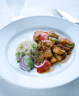 Fisk og grøntsager i fad med hjemmelavet sursød sauce