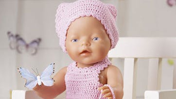Det hæklede sæt til dukken består af både sommerkjole, tørklæde, sko og taske