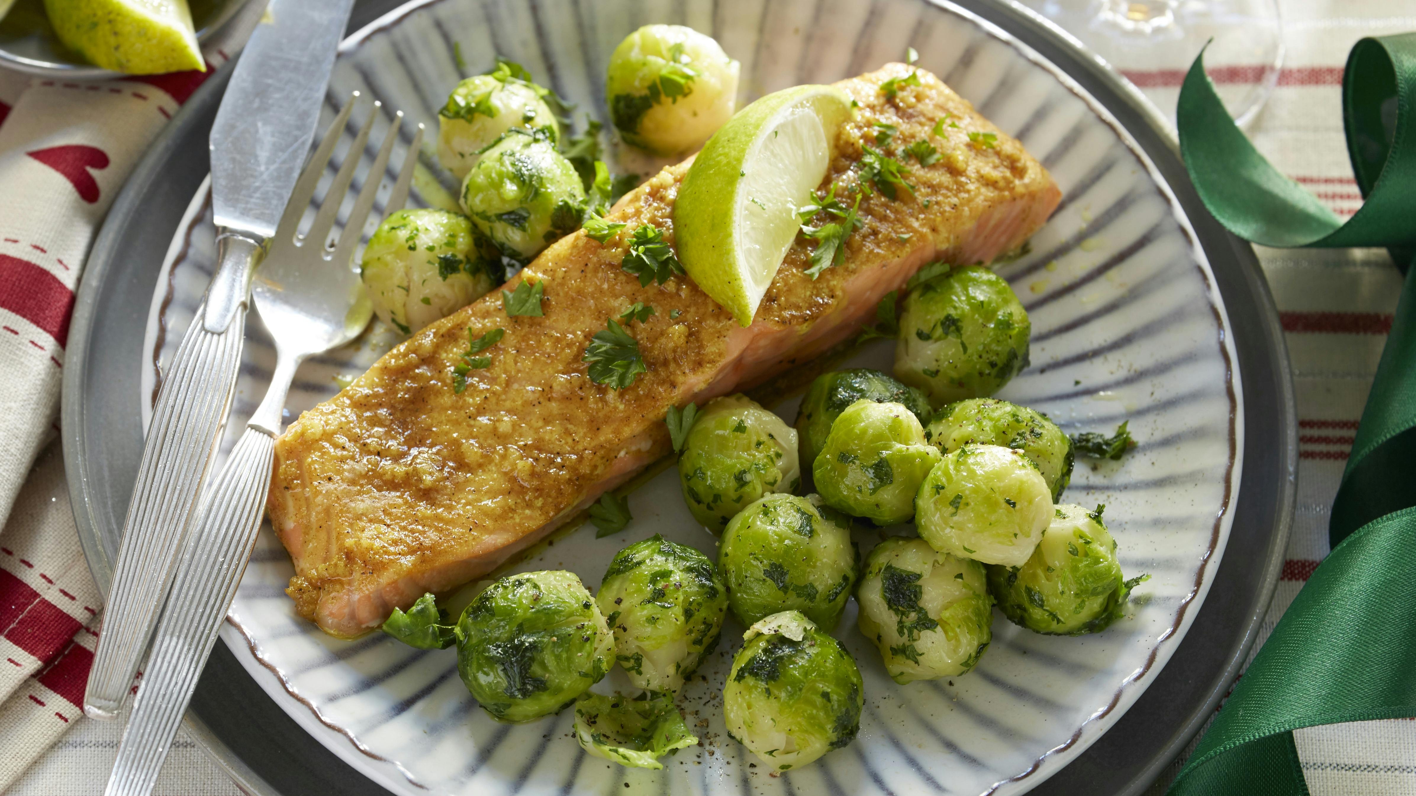 Ovnbagt laks penslet med karry, hvidløg, ingefær og lime. Hertil rosenkål vendt i smør og persille