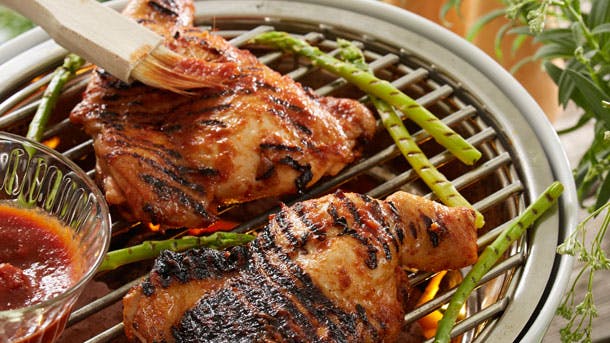 BBQ-kylling på grill, der pensles med marinade