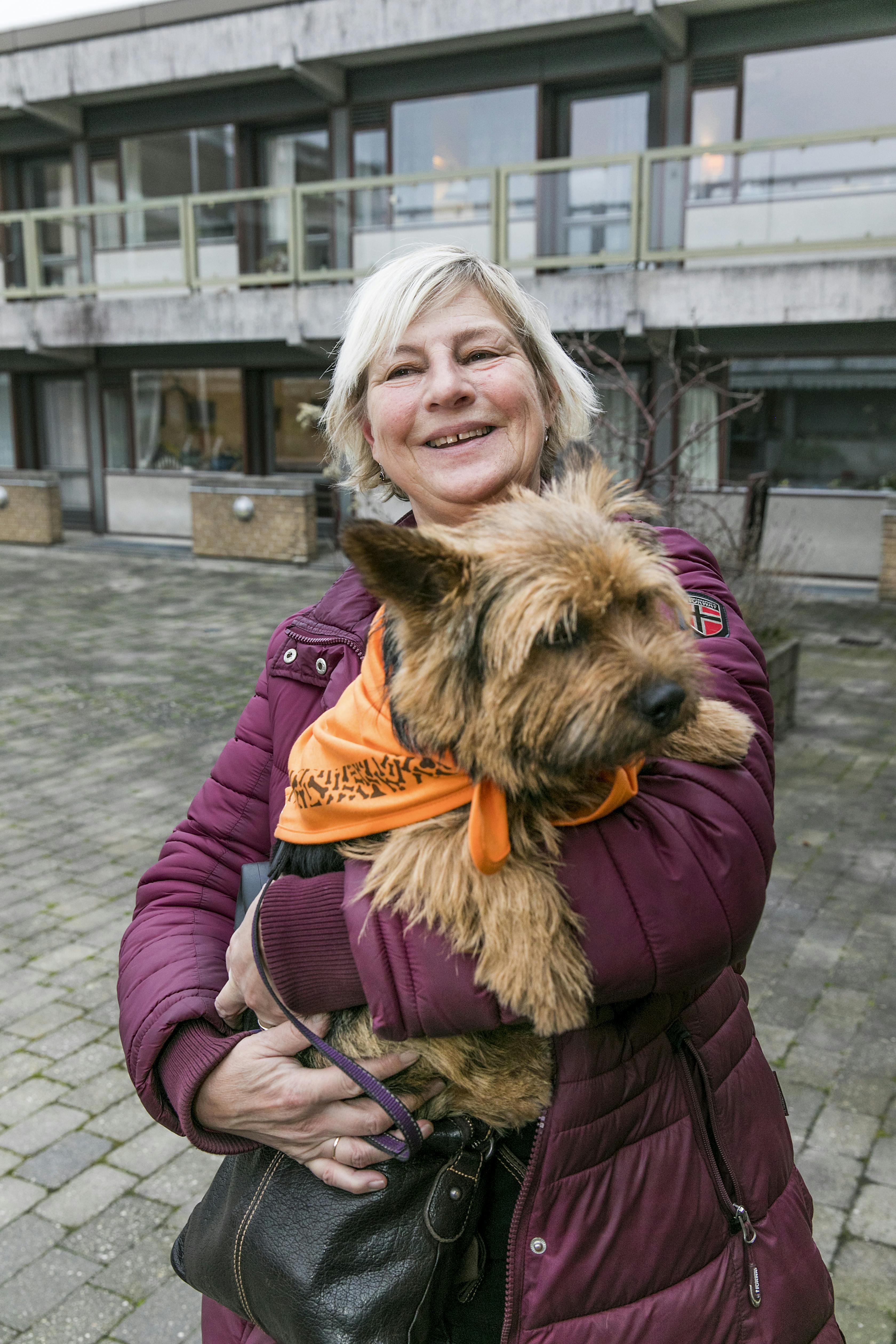 Dame med besøgshund i sin favn