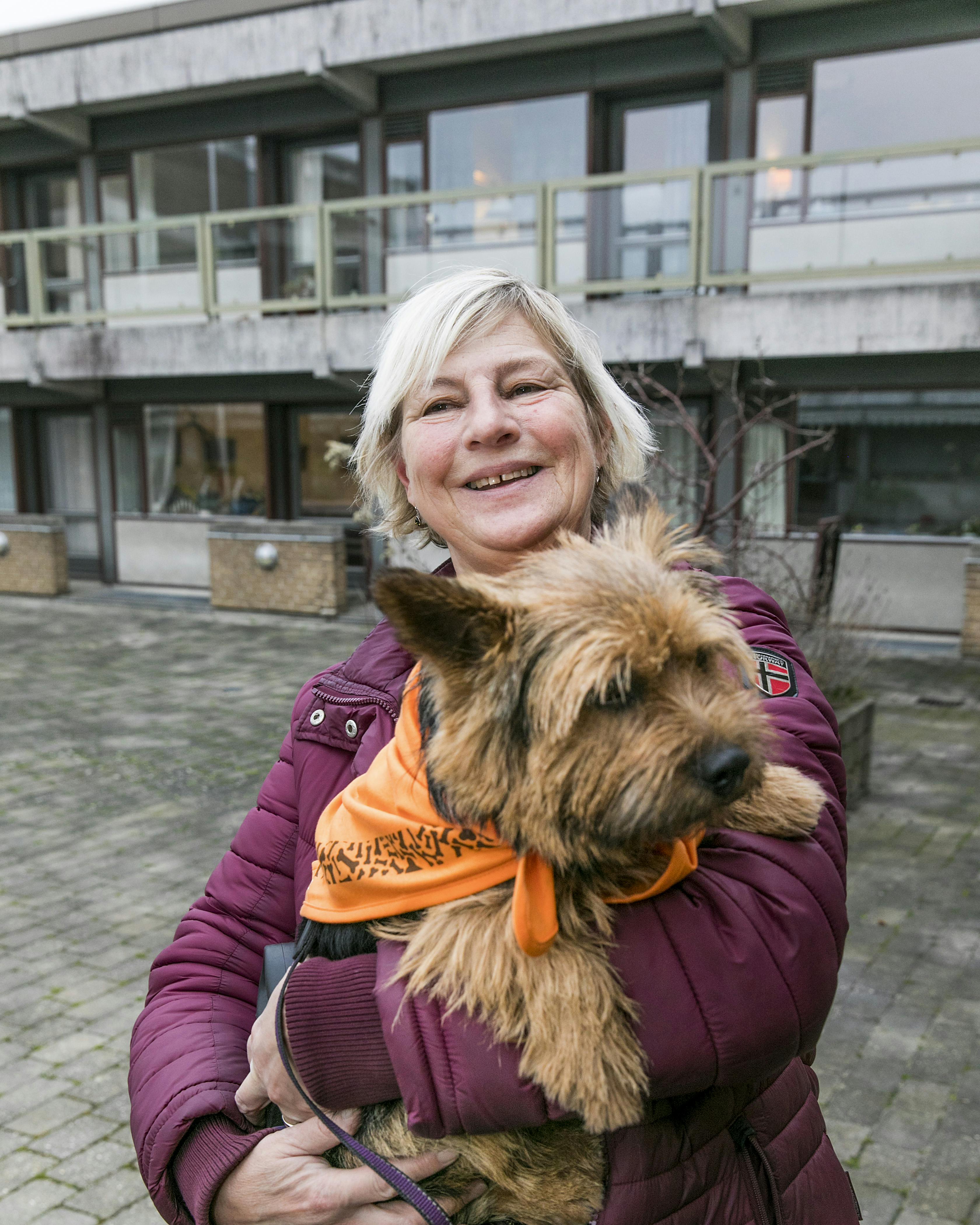 Dame med besøgshund i sin favn