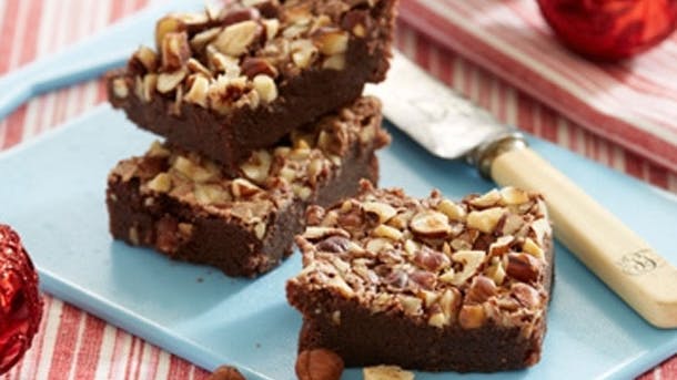 Chokolade-konfekt-kage med hakkede nødder på toppen