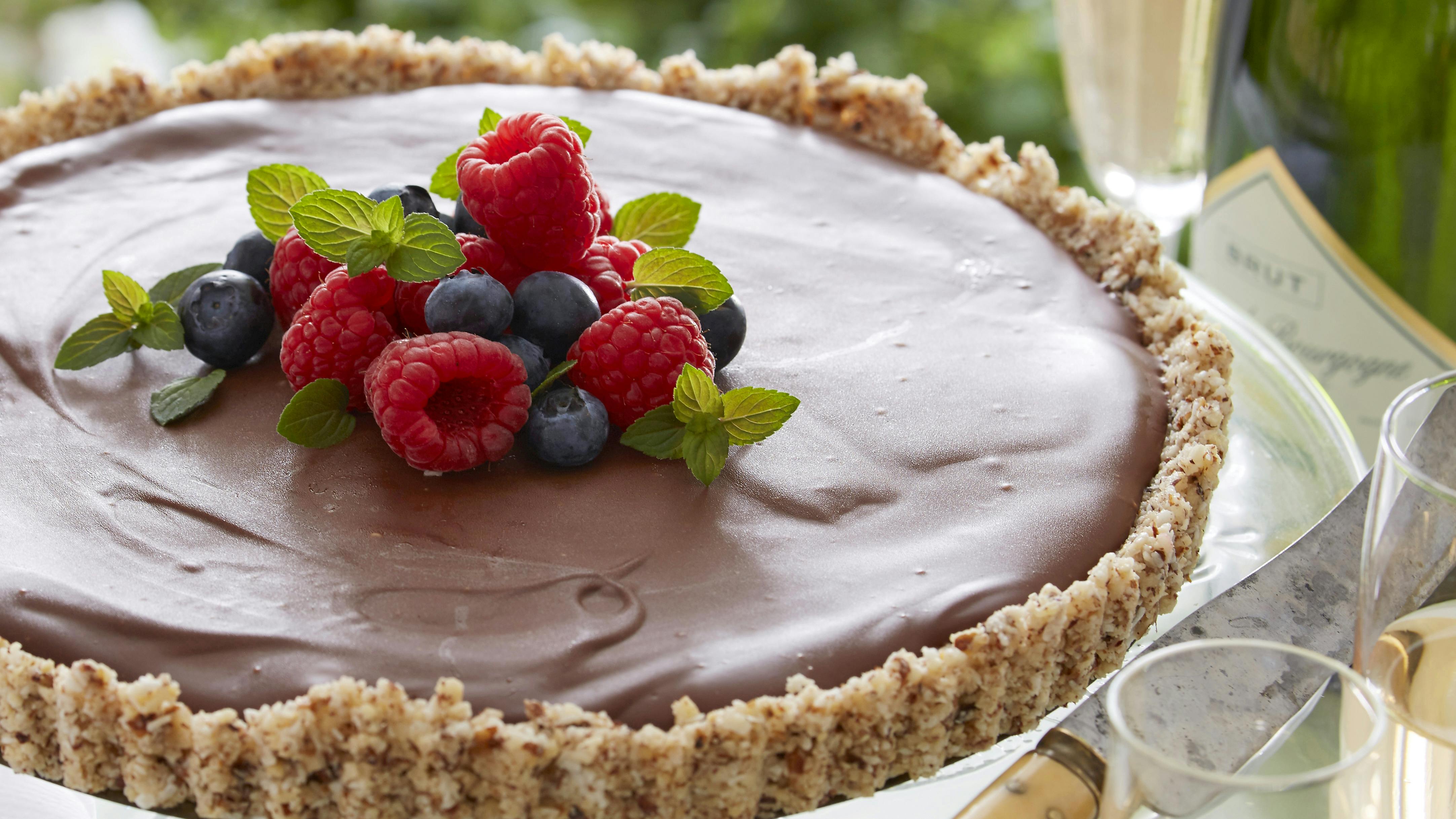 Chokoladetærte med bund af kokos og nødder og fyld af hindbær og chokolade-kokosblanding