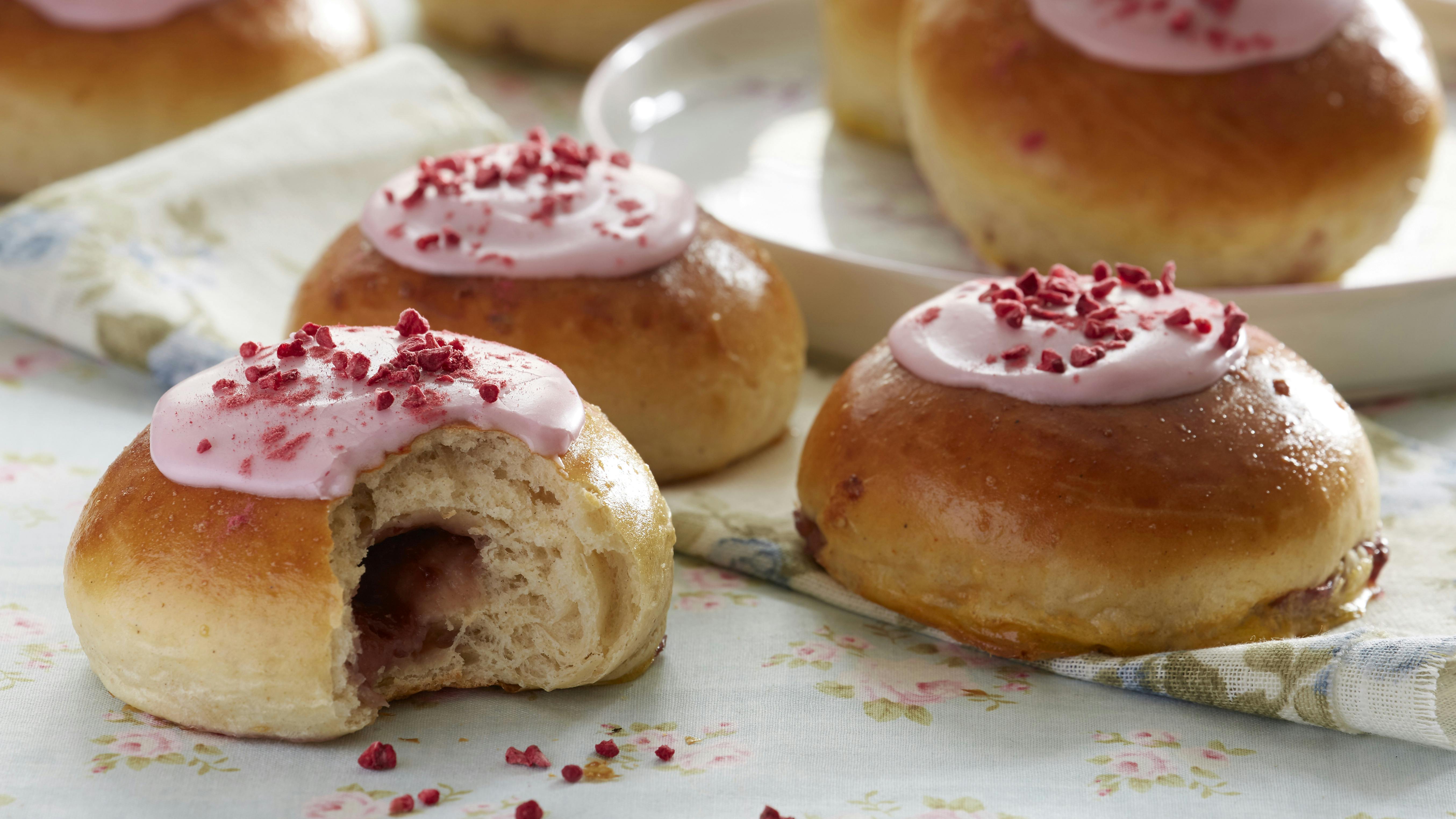 Cremeboller med fyld af hindbærmarmelade og vaniljecreme.På toppen et lag lyserød glasur med tørret hindbær.