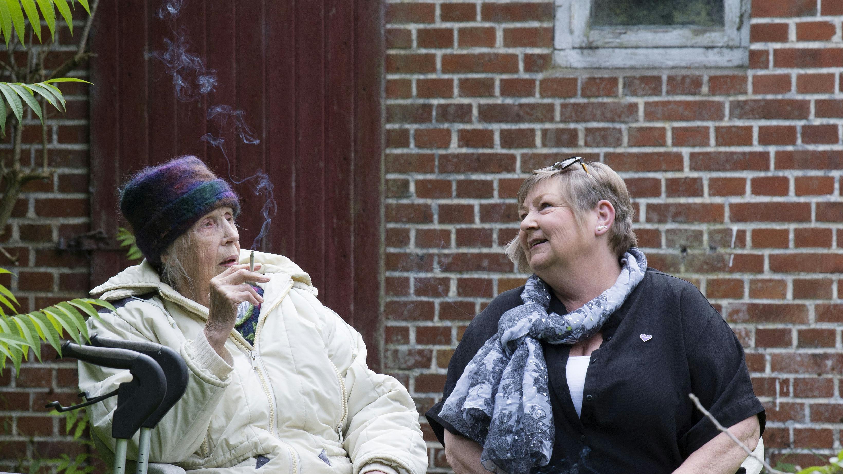 Annemarie er dement sidder i haven med sin demensven