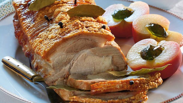 Hel flæskesteg med æbler og brune kartofler