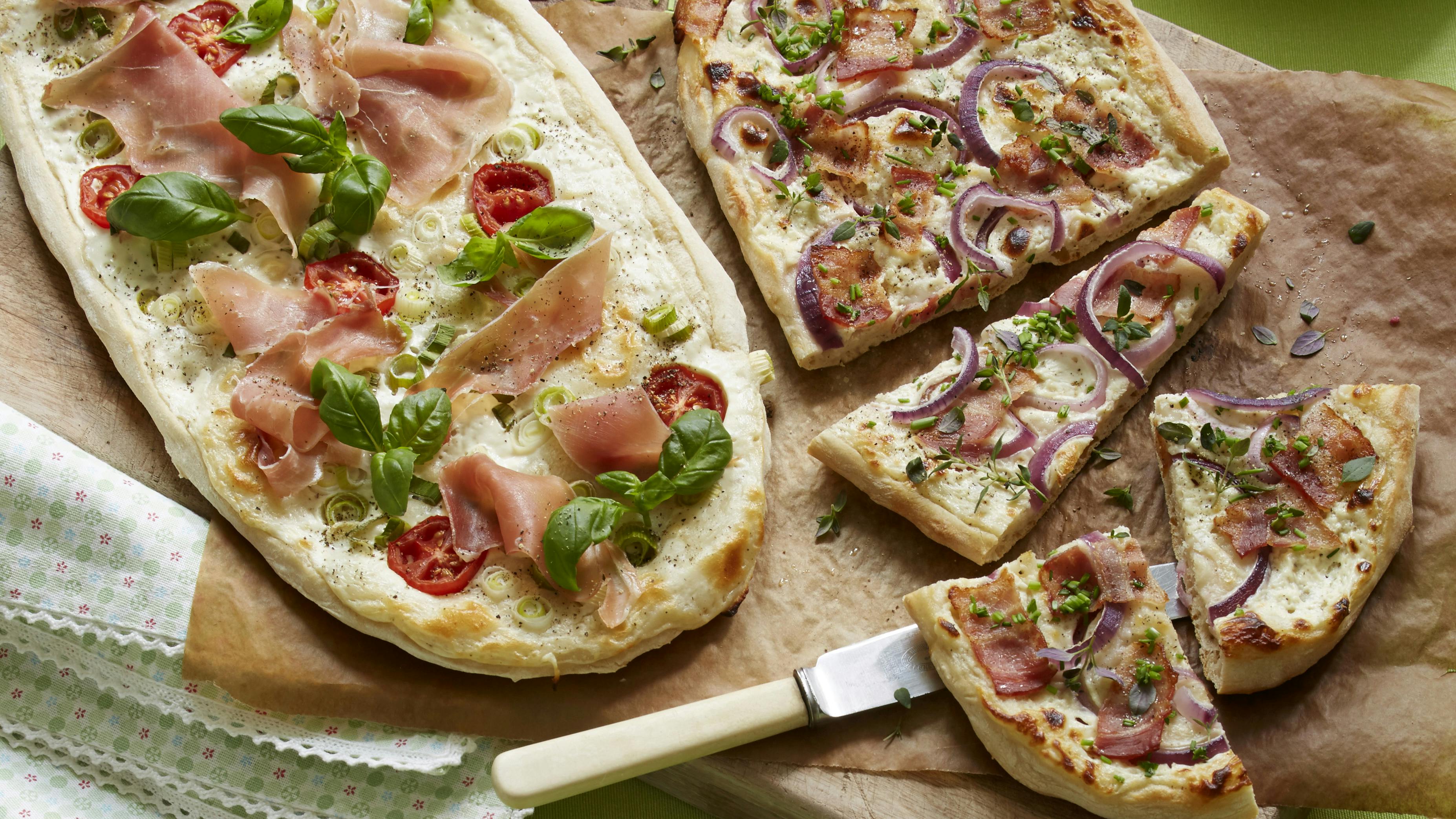 pizza bagt med cremefraiche og kvark i stede for tomatsauce. Her med fyld af skinke, tomat og basilikum