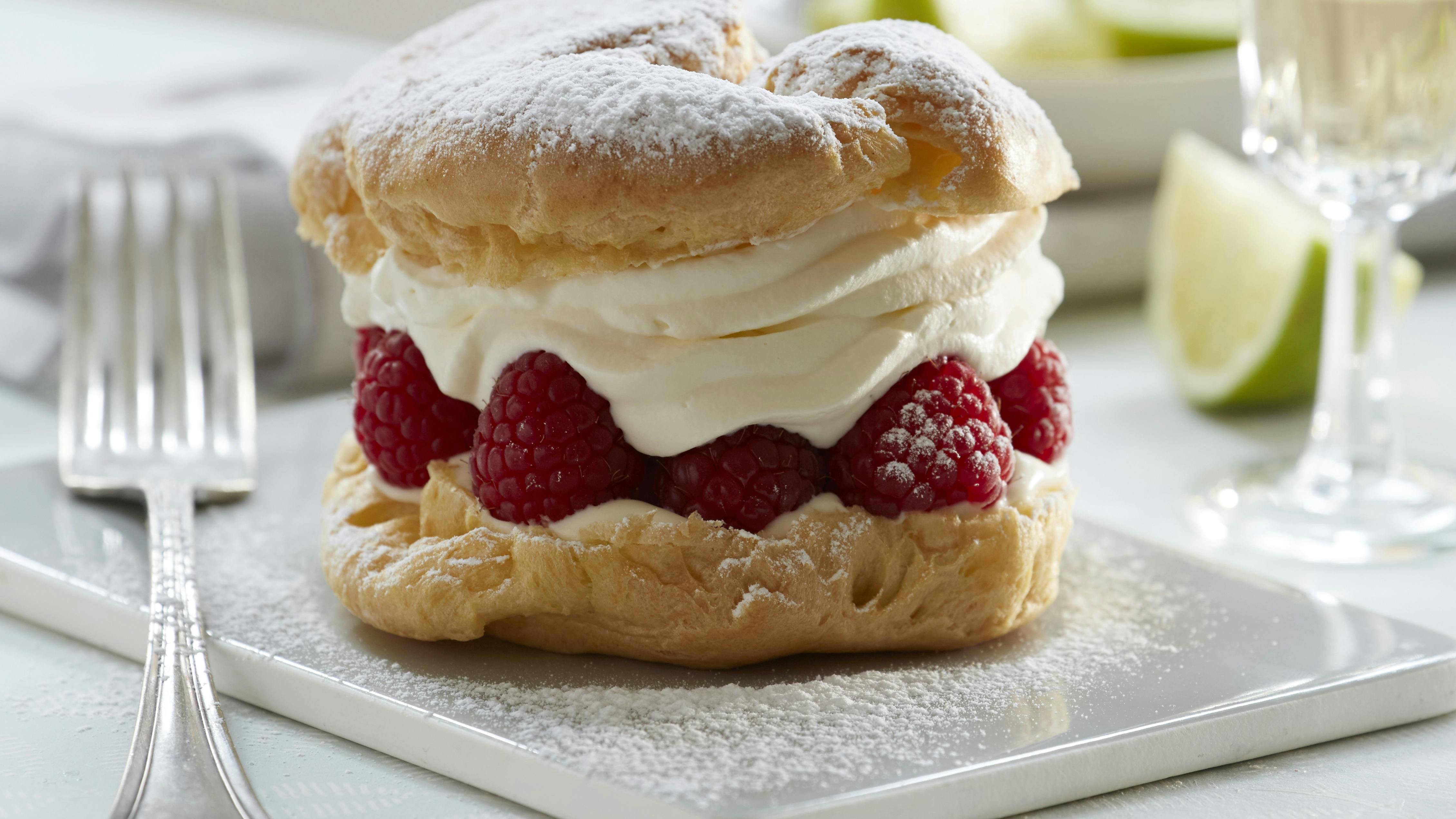 Flødeskumskager af vandbakkelsesdej med fyld af limecreme og friske hindbær
