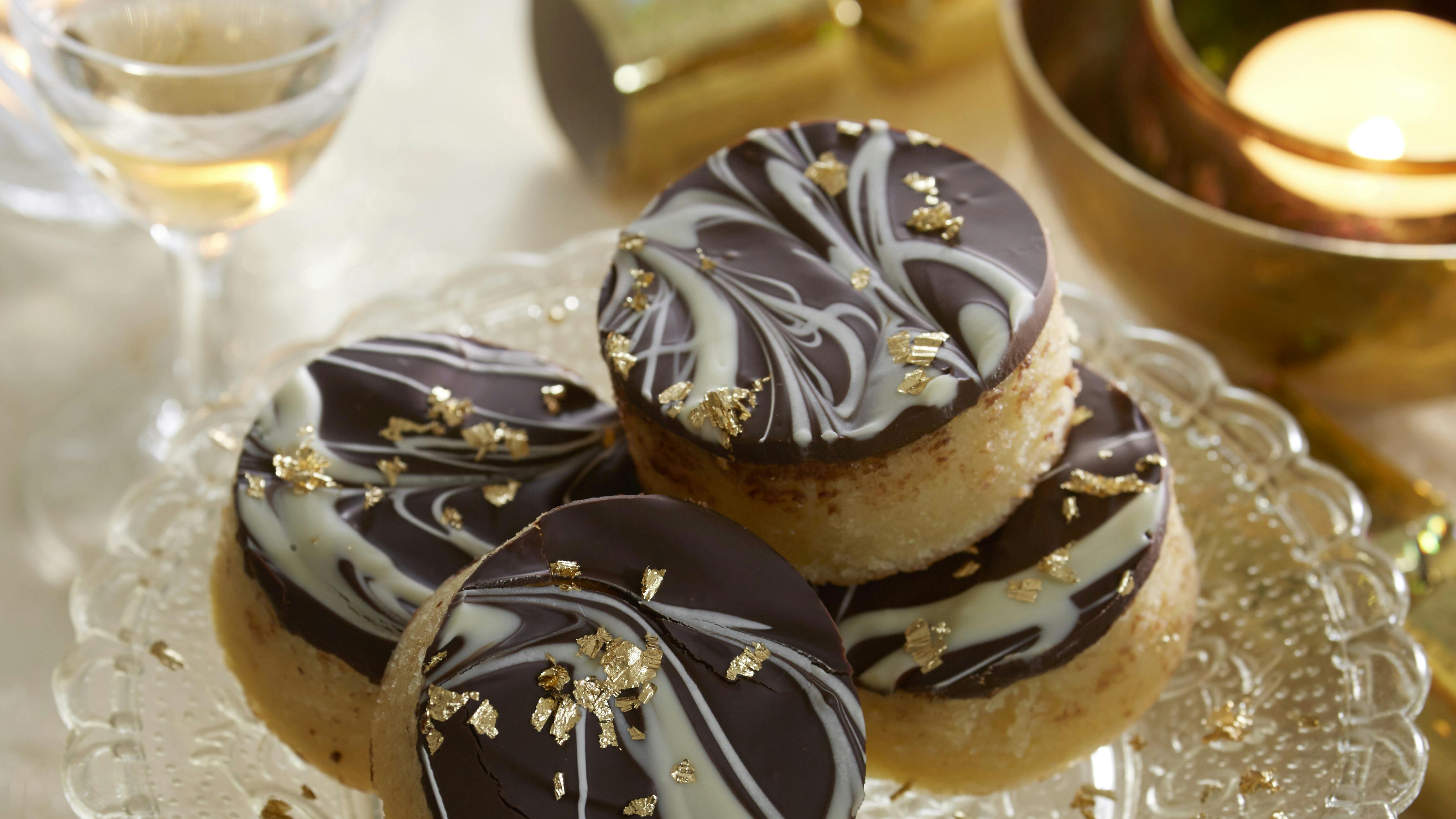 Bradepandekage med marcipan stukket ud i festlige små, runde kager. Kagerne er toppet med mørk og hvid chokolade,