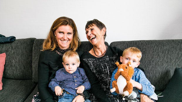 Knæk cancer. To damer sidder i sofa med børn på skødet.