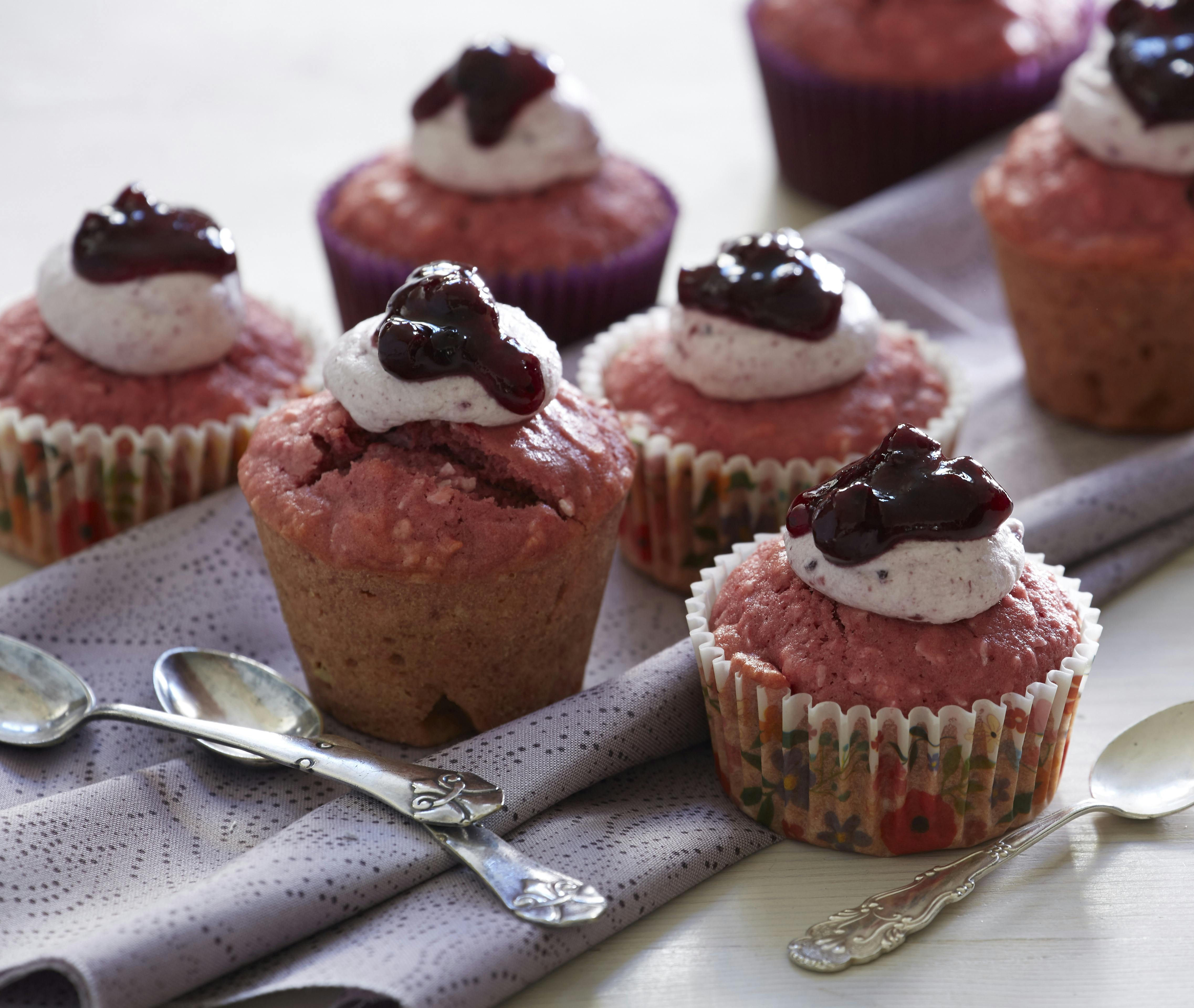 Fine små lyserøde muffins bagt med rødbede og kokos og toppet med flødeskum og solbærsyltetøj