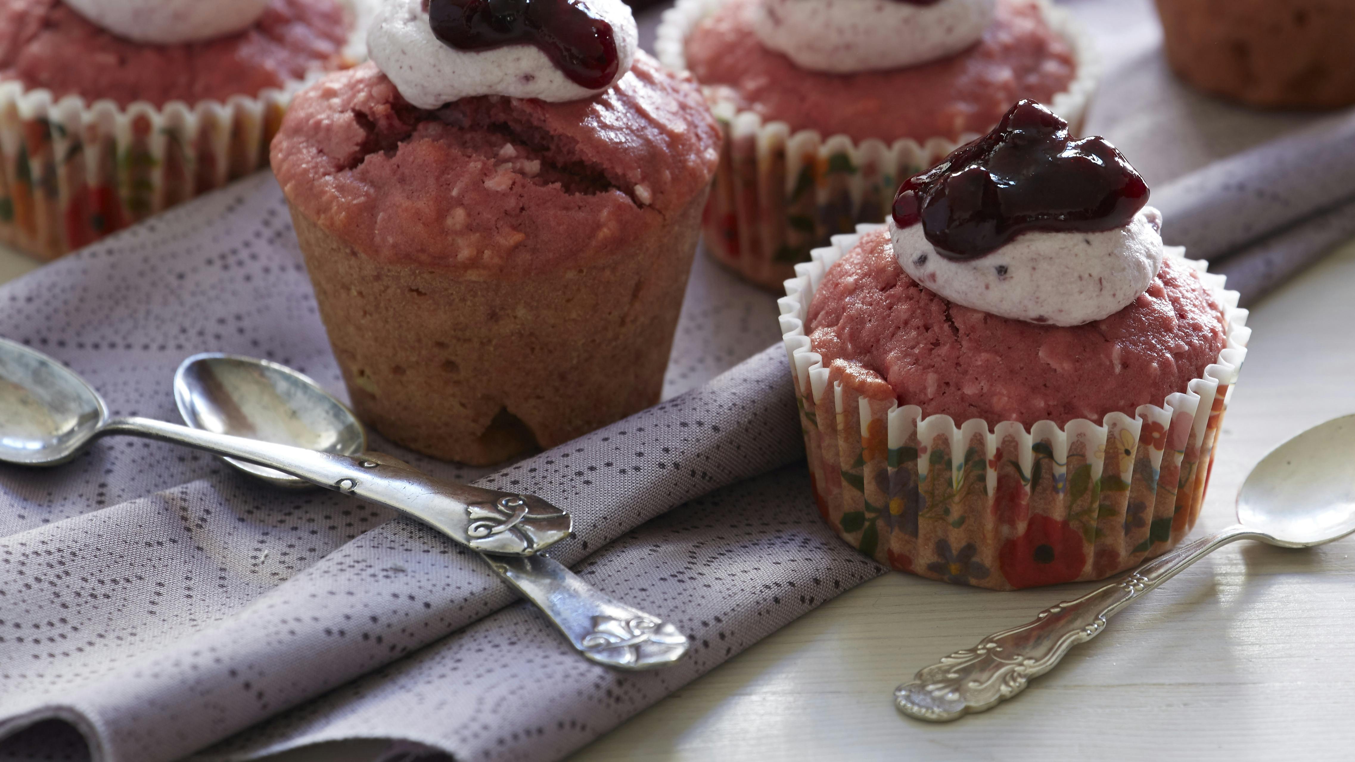 Fine små lyserøde muffins bagt med rødbede og kokos og toppet med flødeskum og solbærsyltetøj