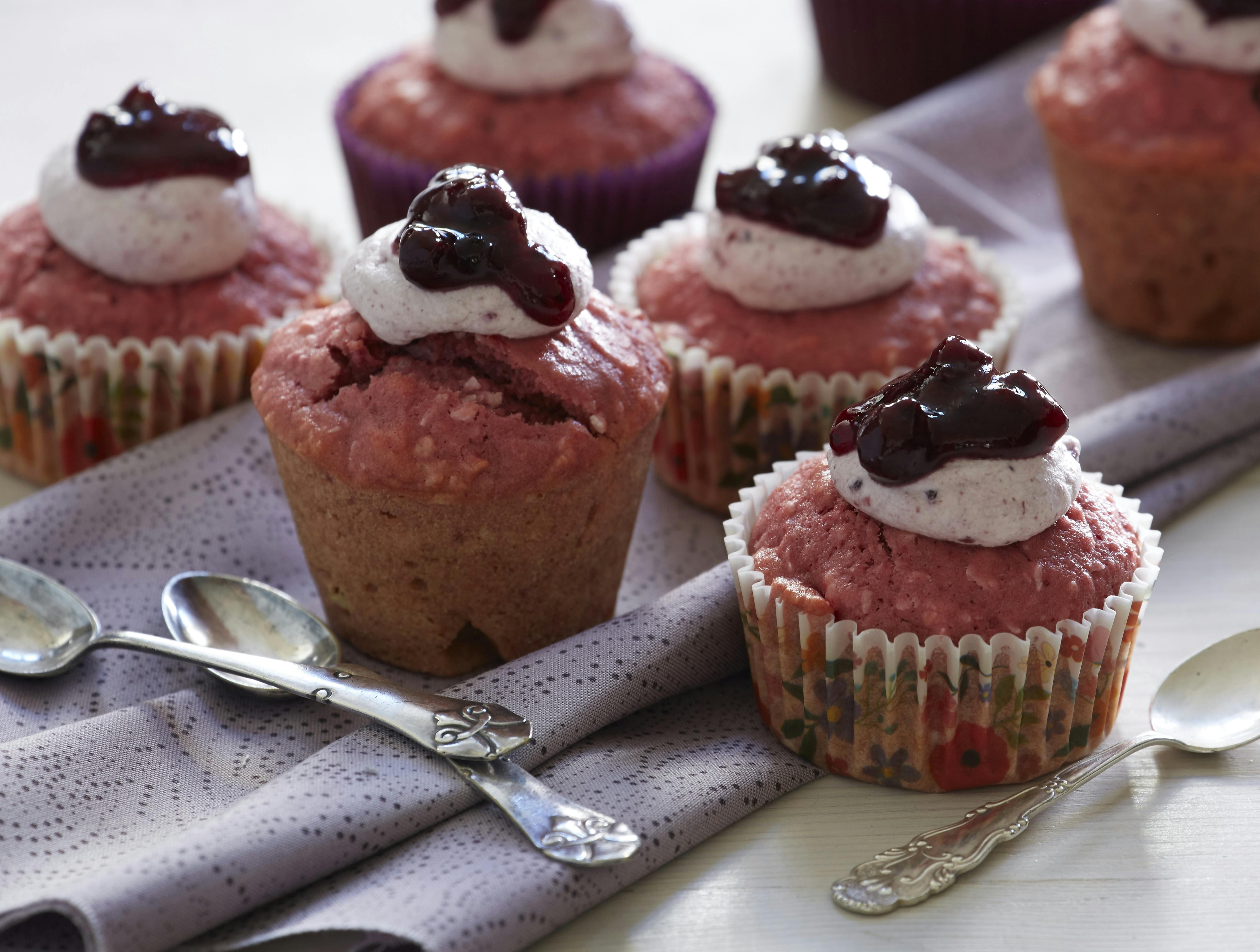 Fine små lyserøde muffins bagt med rødbede og kokos og toppet med flødeskum og solbærsyltetøj