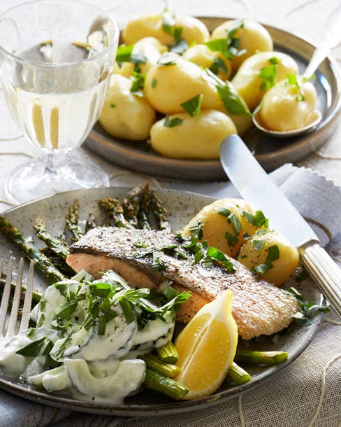 Ørredfilet med asparges og cremet agurkesalat på tallerken