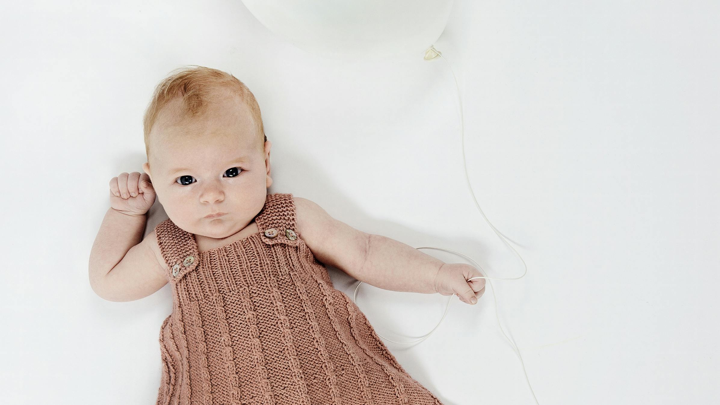 Strik en fin spencer med snoninger til baby