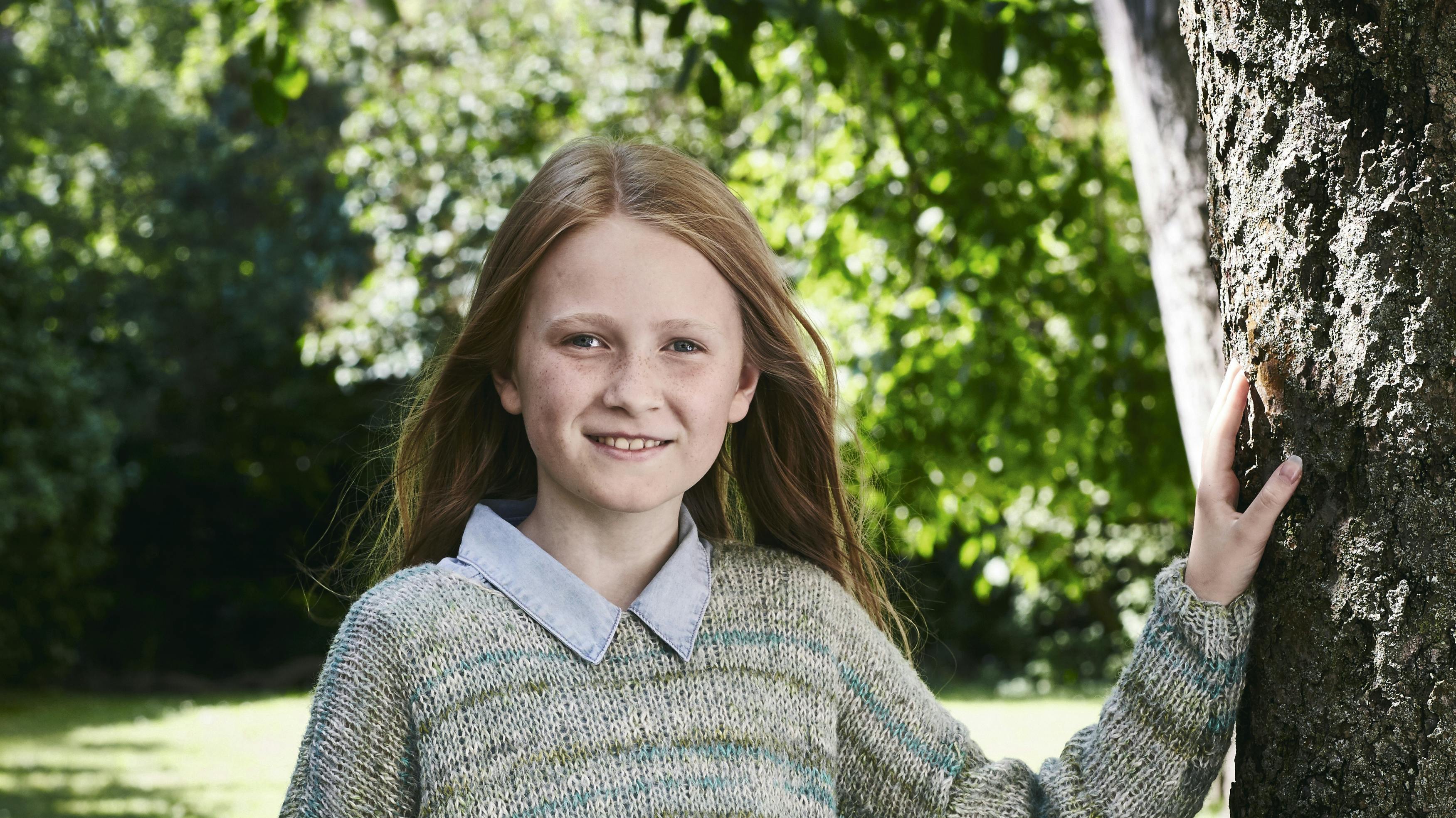 Pige i bred sweater med striber - gratis strikkeopskrift