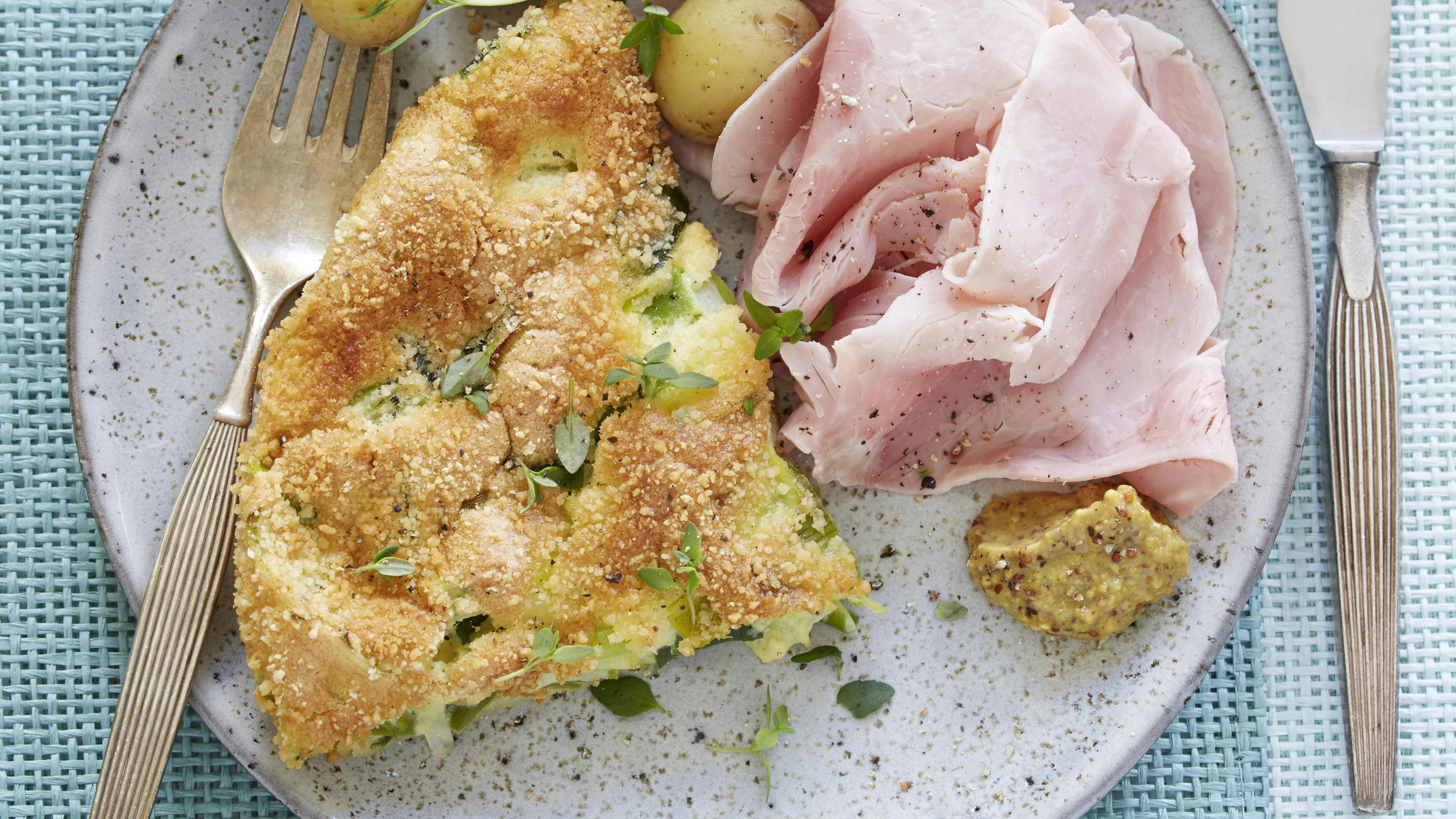 Porregratin serveret med skiver af skinke, sennep og kogte kartofler eller rugbrød