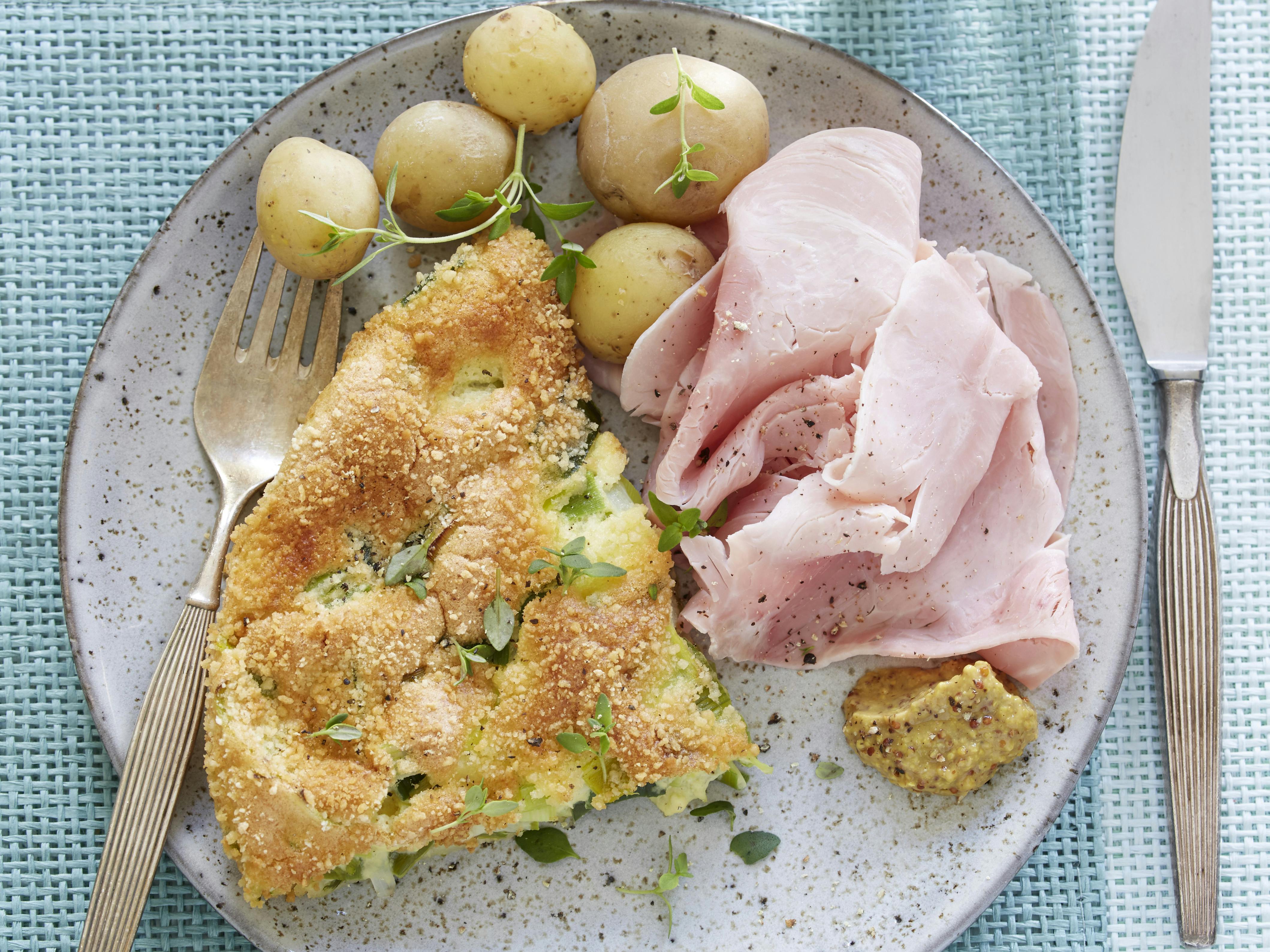 Porregratin serveret med skiver af skinke, sennep og kogte kartofler eller rugbrød