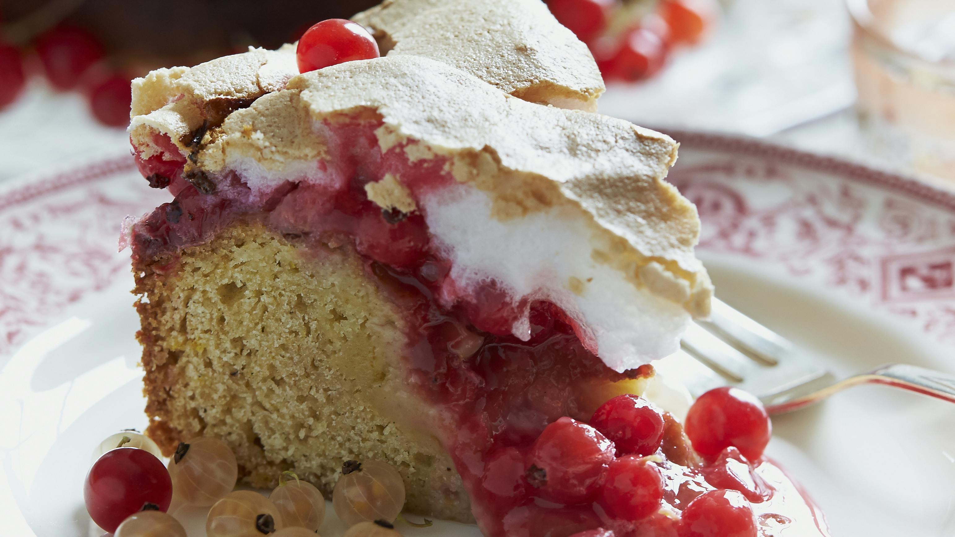 Ribskage toppet med et lag marengs med ribs. Kagen er pyntet med friske bær.