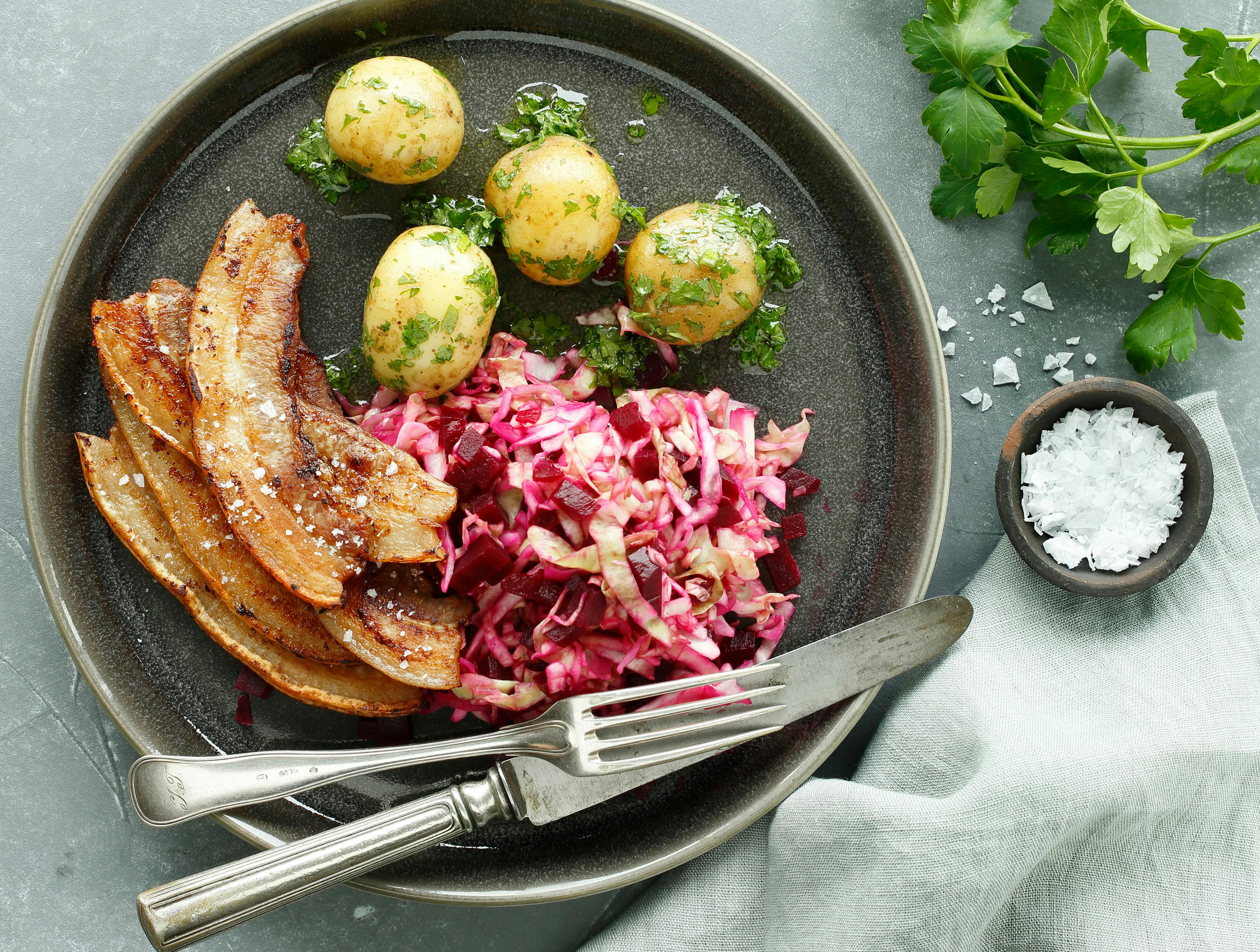 Her får du opskriften på nyfortolkning af Danmarks nationalret: stegt flæsk. Flæsket serveres med kartofler, persillesmørsovs og en sprød kålsalat. Velbekomme. 