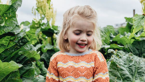 Lille pige med orange pigebluse med flæse
