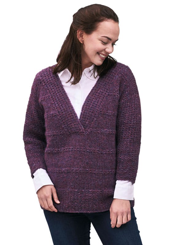 Dame i stor lilla sweater med v-hals. Strikkeopskrift