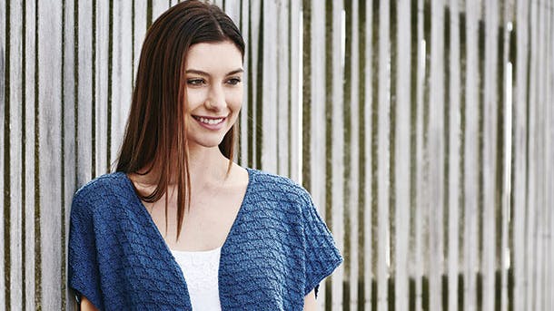 Dame i blå strikket vest i bomuld, silke og hamp