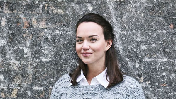 Dame i grå sweater med påfuglemønster