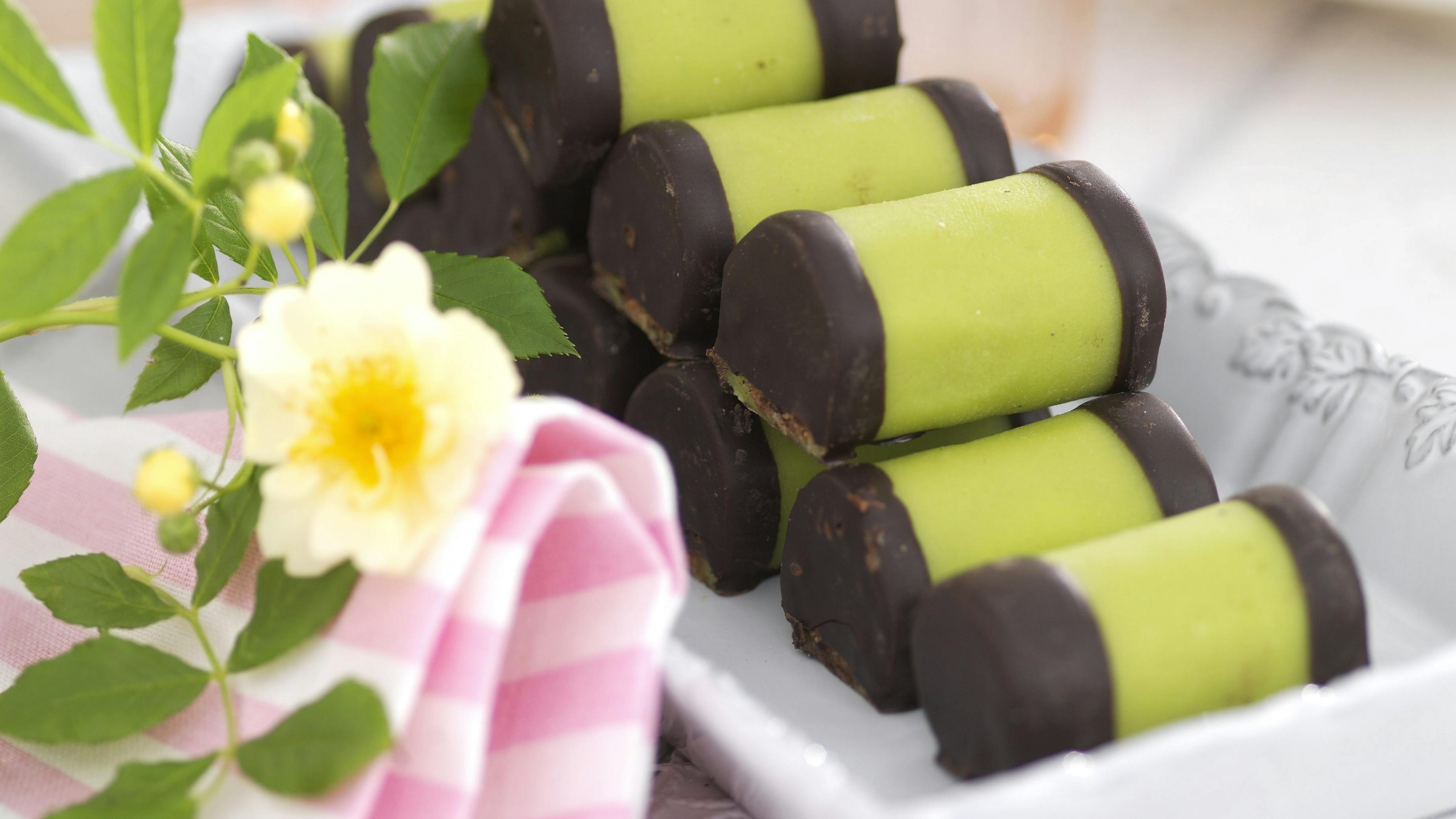 Træstammer er små ruller af kagedej med kakao og rom, som er omviklet med grøn marcipan og dyppet i chokolade i enderne