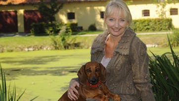 Sognepræsten ved ?landsbyens gadekær? i Slagslunde med hunden Kastania, som hun med glimt i øjet kalder for sit ?fjerde barn?. Foto: Birger Vogelius