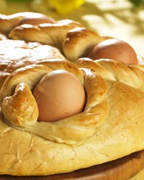 Rundt påskebrød bagt med hele æg i små reder