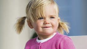 Strikket lyserød pigejakke med dekorative rillekanter på bærestykket