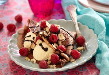 Kakao pandekager serveret med vaniljeis, chokoladesovs og hindbær