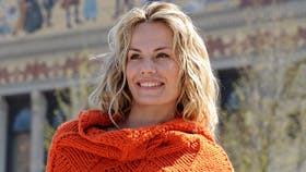 Strikket, orange sjal med sorte pomponer