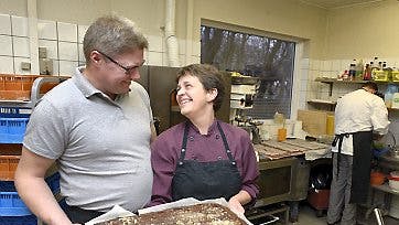 Browniekagen til aftenens dessert er naturligvis hjemmebagt og de kærlige følelser mellem værten og hendes ægtemand ikke til at tage fejl af.